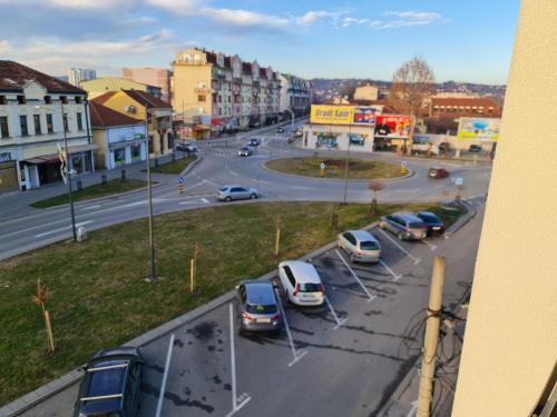 a city street with cars parked in a parking lot at Grand Lux apartman in Čačak