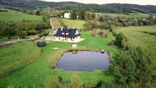 an aerial view of a house on a hill with a pond at Pod Nartami in Hoczew