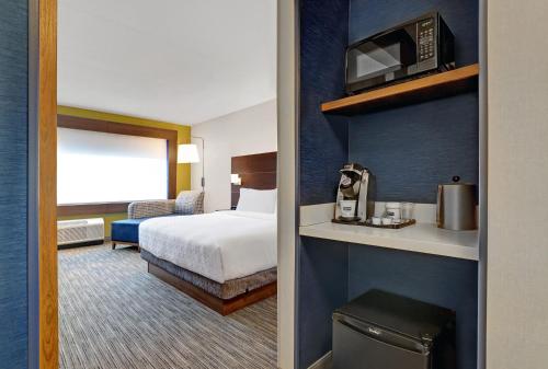 a hotel room with a bed and a microwave at Holiday Inn Express - Kingston West, an IHG Hotel in Kingston