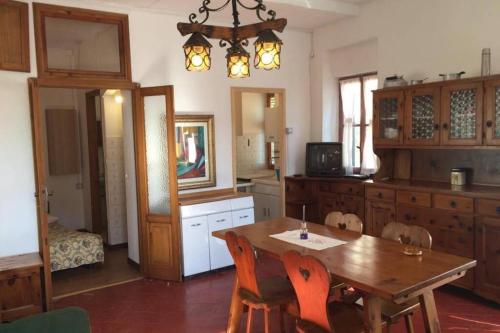 una cucina con tavolo in legno e una sala da pranzo di Nel set di piccolo mondo antico Villa Viola a Valsolda
