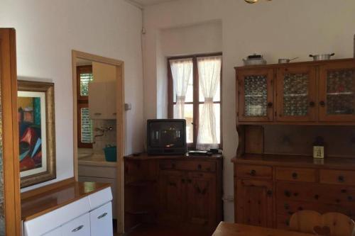 ein Wohnzimmer mit einem TV auf einer Holzkommode in der Unterkunft Nel set di piccolo mondo antico Villa Viola in Valsolda