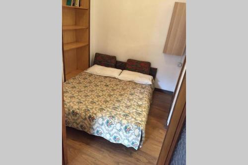 a small bedroom with a bed and a book shelf at Nel set di piccolo mondo antico Villa Viola in Valsolda