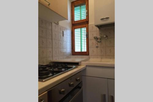 a kitchen with a stove and a sink at Nel set di piccolo mondo antico Villa Viola in Valsolda