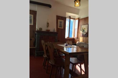 a dining room with a wooden table and chairs at Nel set di piccolo mondo antico Villa Viola in Valsolda