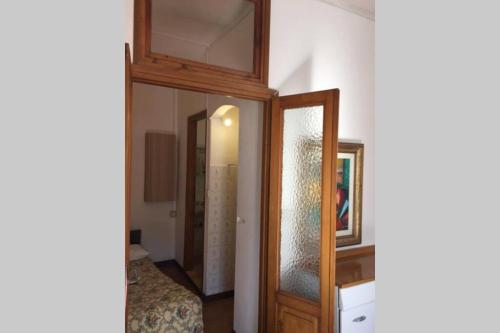 a door to a bedroom with a mirror and a bed at Nel set di piccolo mondo antico Villa Viola in Valsolda