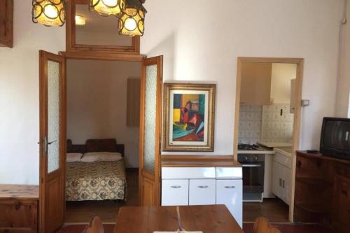 a living room with a table and a kitchen at Nel set di piccolo mondo antico Villa Viola in Valsolda