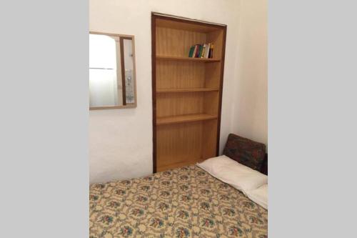 a bedroom with a bed and a book shelf at Nel set di piccolo mondo antico Villa Viola in Valsolda