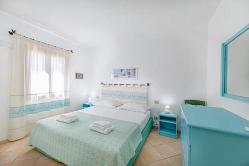 1 dormitorio con 1 cama con toallas en Sardinia Blu Residence, en Golfo Aranci
