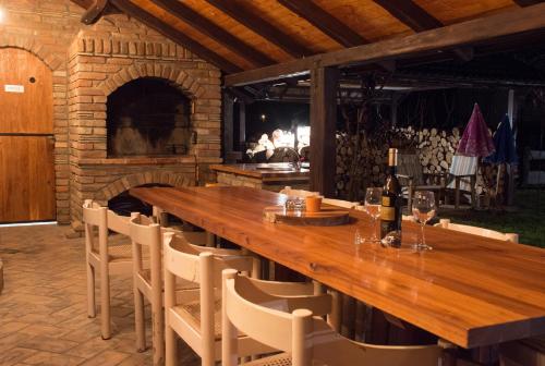 a large wooden table with chairs and a fireplace at "Vučedol"- kuća za odmor **** in Vukovar