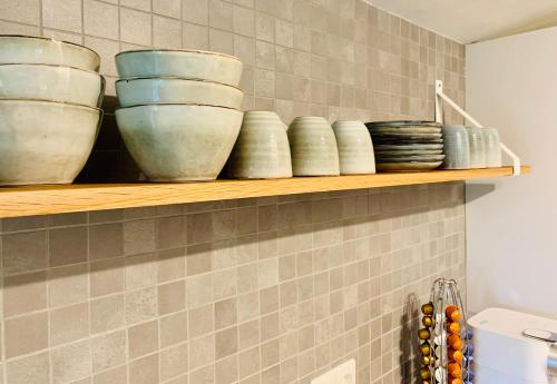 a shelf with bowls on it in a kitchen at So Rosie in Babberich