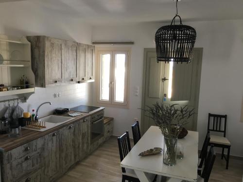 a kitchen with wooden cabinets and a table with a white tableablish at Villa Tranquilita in Kastraki Naxou