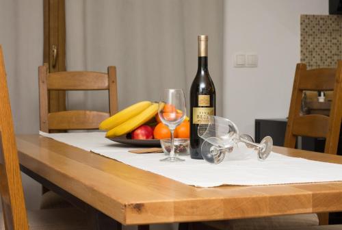 a table with a bottle of wine and a bowl of fruit at "Vučedol"- kuća za odmor **** in Vukovar