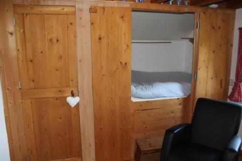 1 dormitorio con litera y silla negra en Appartement Het Kleine Huisje met bedstee, en Giethoorn