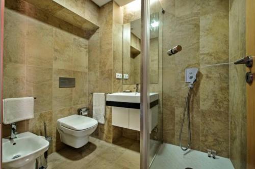 een badkamer met een toilet, een wastafel en een douche bij Villa Lux - 5O in Luz de Tavira