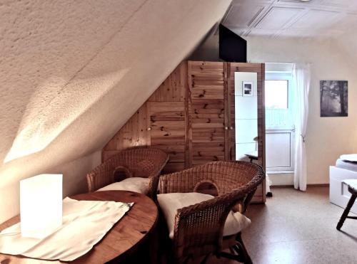 a dining room with a table and wicker chairs at Pension Hohaus in Neuharlingersiel
