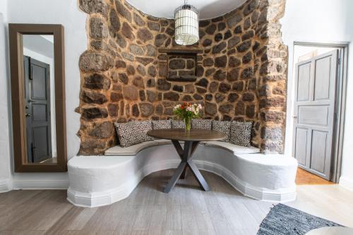 Habitación con mesa y pared de piedra. en Hotel Boutique El Palomar, en San Miguel de Allende