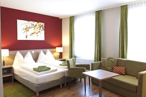 um quarto de hotel com uma cama e um sofá em Gasthof Schmölz em Sankt Christophen