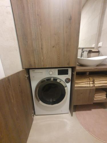 a washing machine in a bathroom with a sink at Bjelasnica Tuzlaks Apartment -SAUNA-free parking in Bjelašnica
