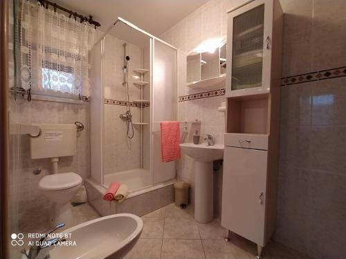 a bathroom with a toilet and a shower and a sink at 21 Kosinac GREEN PARADISE in Vinišće
