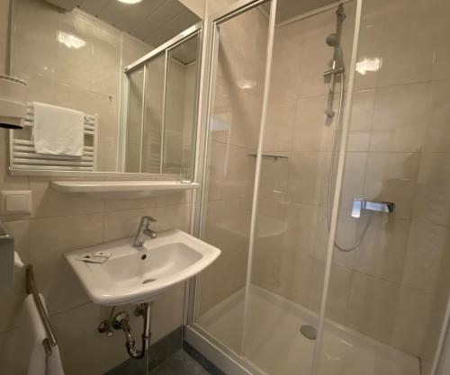 
a bathroom with a sink and a shower at Hotel-Restaurant Faustschlössl in Feldkirchen an der Donau
