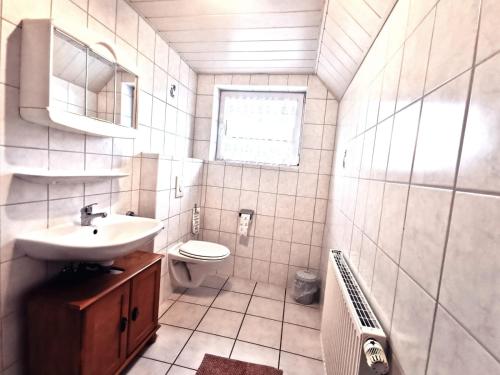 a bathroom with a sink and a toilet at Pension Hohaus in Neuharlingersiel