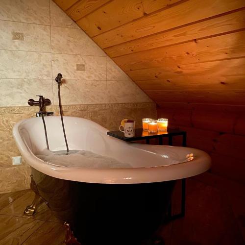 a bath tub in a room with a wooden ceiling at BORYSÓWKA in Kopanica