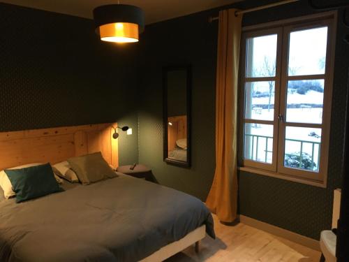Chambles的住宿－Ess'folie Gîte，一间卧室设有一张床和一个窗口