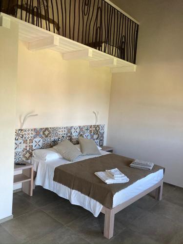 a bedroom with a bed with a staircase above it at ALELCA DOMO in Buggerru