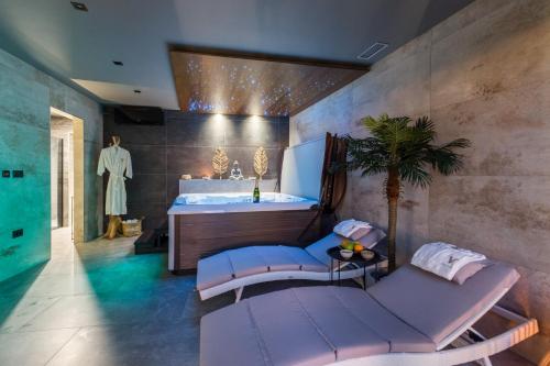 ein Badezimmer mit einer Badewanne, einem Waschbecken und einer Couch in der Unterkunft Villa Vie in Medulin