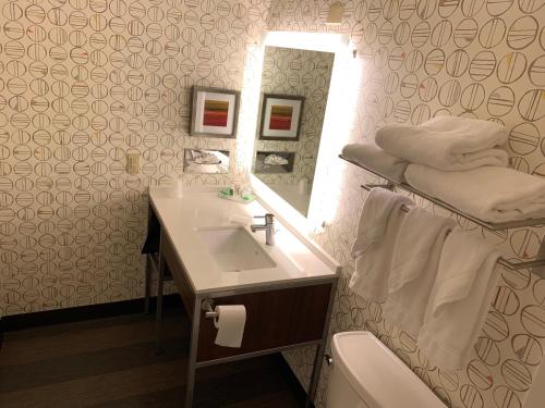 ein Bad mit einem Waschbecken und einem Spiegel in der Unterkunft Holiday Inn Baton Rouge-South, an IHG Hotel in Baton Rouge