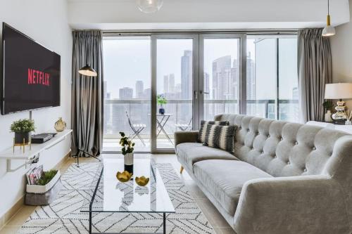 a living room with a large couch and a large window at GuestReady - Downtown Boulevard in Dubai