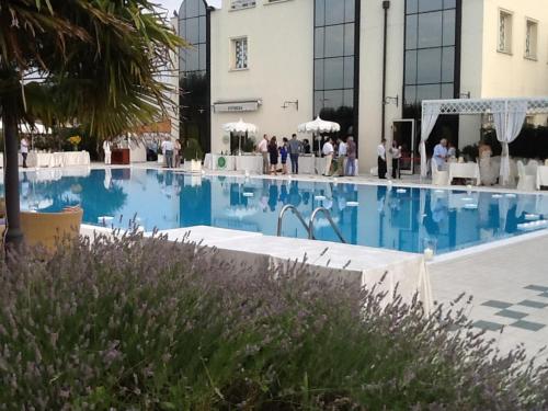 a large swimming pool with people standing around a building at Zanhotel Centergross in Bentivoglio