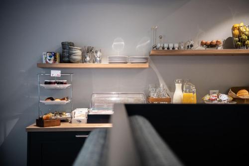 a kitchen with a counter and shelves with food at Hotel Gerig in Wassen
