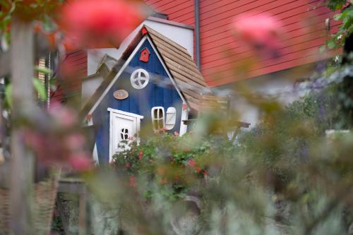 a small blue house with a red roof at Hotel Gerig in Wassen