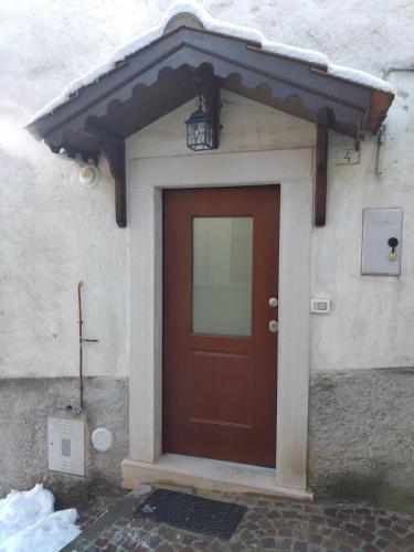 a red door with awning above it on a building at Piccolo Paradiso in pieno centro Rivisondoli in Rivisondoli