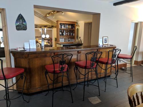 a dining room with a bar and chairs at Elderbrook House in Avebury