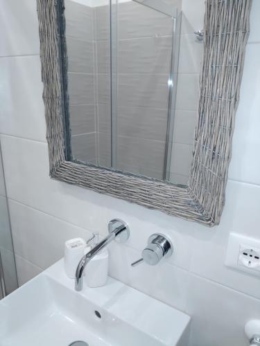 La salle de bains est pourvue d'un lavabo et d'un miroir. dans l'établissement Piccolo Paradiso in pieno centro Rivisondoli, à Rivisondoli