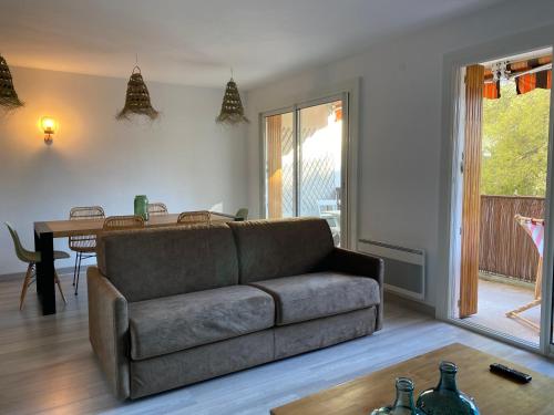 un salon avec un canapé et une table dans l'établissement Appartement Le Panoramic - Terrasse et Parking, à Cassis