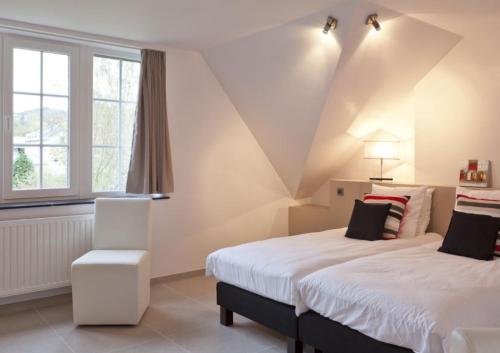 um quarto com 2 camas e uma janela em Le Rimamir gîte de charme au bord de l’Amblève em Aywaille