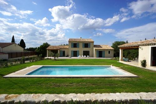 une maison avec une piscine dans la cour dans l'établissement Gîte de Notre Dame, à Saint-Étienne-du-Grès