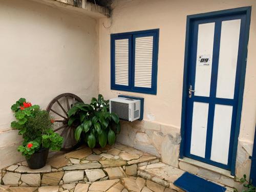 a door to a house with a fan and plants at Pousada Locomotiva 206 in Conservatória