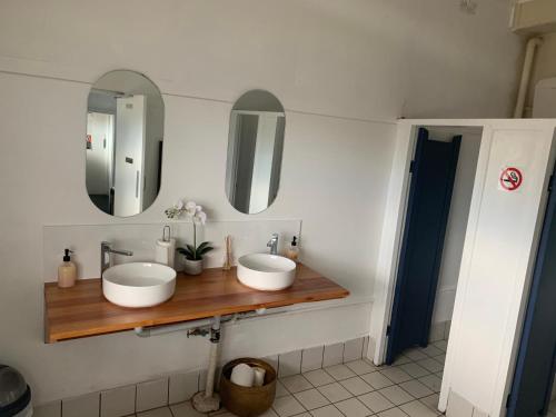 a bathroom with two sinks and two mirrors at Hotel Koorawatha in Koorawatha