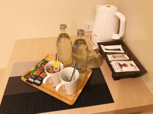 uma mesa com duas garrafas e uma bandeja de bebidas em SJ Miracle Hotel em Hat Yai