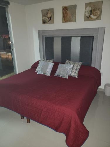 マサトランにあるDepartamento en malecon Portico Beachのベッドルーム1室(赤いベッド1台、枕付)