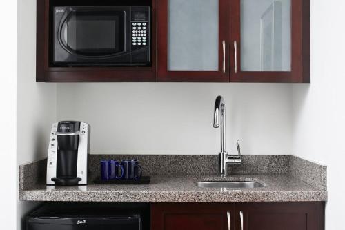 a kitchen counter with a sink and a microwave at Club Quarters Hotel Faneuil Hall, Boston in Boston
