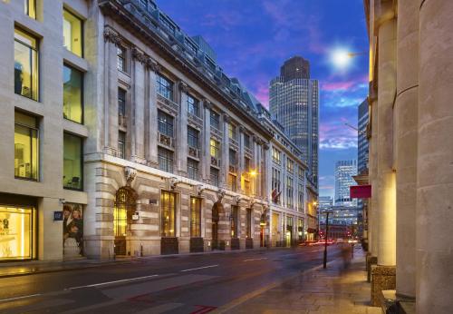 una strada di città di notte con edifici alti di Club Quarters Hotel London City, London a Londra