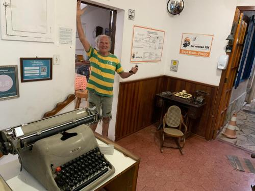 a man standing in a room with a typewriter at Pousada Locomotiva 206 in Conservatória