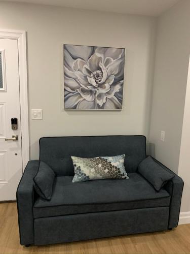 a couch in a living room with a flower painting at Woodslee Bed and Breakfast in Belle River