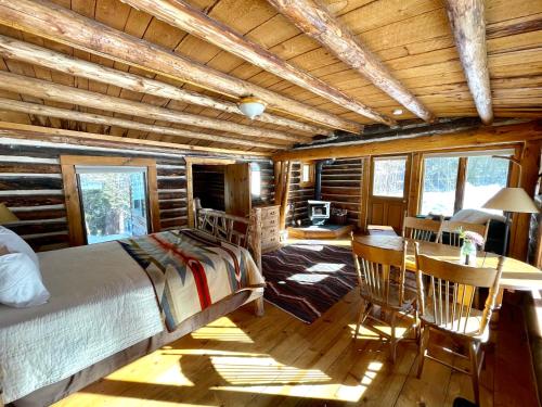 a bedroom in a log cabin with a bed and a table at Beyul Retreat in Meredith