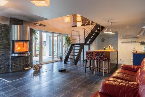 a living room with a couch and a fireplace at Holiday House Koceri in Ķekava
